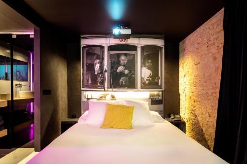 a bedroom with a white bed with a yellow pillow at Zrooms&Suites Hostel Boutique in Zaragoza