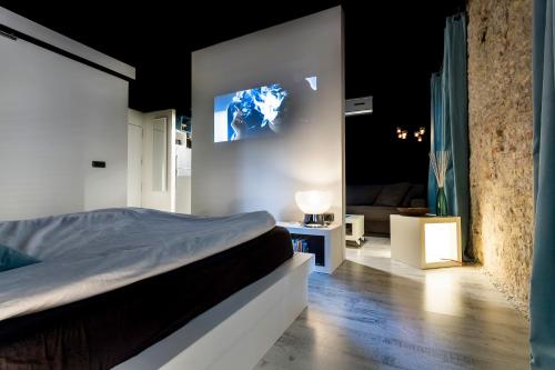 a bedroom with a bed and a tv on the wall at Zrooms&Suites Hostel Boutique in Zaragoza