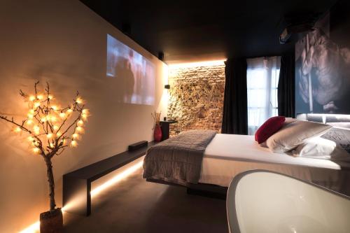 a bedroom with a bed and a tree with lights at Zrooms&Suites Hostel Boutique in Zaragoza