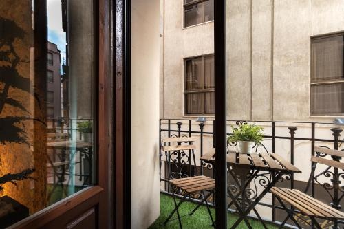 a balcony with a table and chairs on a building at Zrooms&Suites Hostel Boutique in Zaragoza
