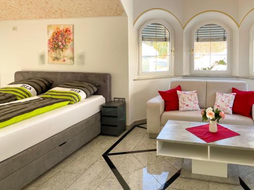 ein Schlafzimmer mit einem großen Bett und einem Sofa in der Unterkunft Villa Victoria in Hermagor