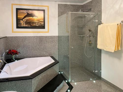 a bathroom with a shower and a tub and a sink at Villa Victoria in Hermagor