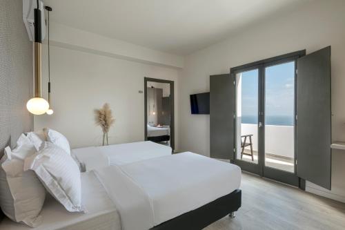 una camera da letto con un letto e vista sull'oceano di Pearl Inn Hotel by Pearl Hotel Collection a Imerovigli