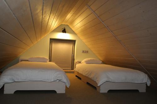 two beds in a room with a attic at Garden Apartment in Cēsis