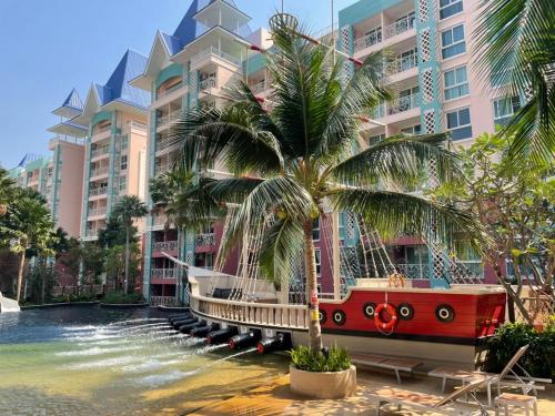 un bateau dans l'eau devant un bâtiment dans l'établissement Grande Caribbean Condo Resort TLH, à Pattaya (sud)