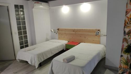 two beds in a room with white walls at valencialoft in Valencia
