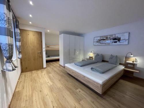 Schlafzimmer mit einem Bett und Holzboden in der Unterkunft Appartement Mona in Bürserberg