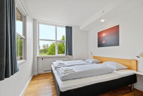 a bedroom with two beds and two windows at Ribe Byferie Resort in Ribe