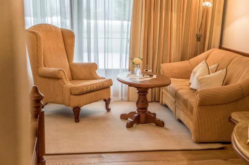 a living room with a couch and a chair and a table at Der Lärchenhof in Erpfendorf