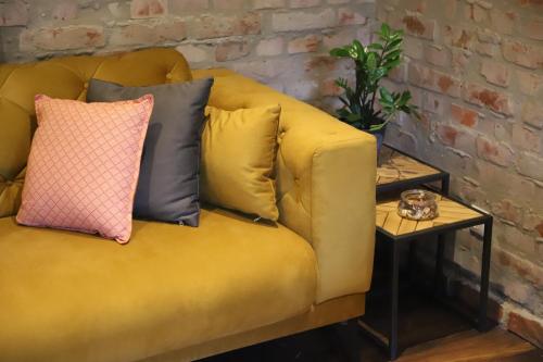 a yellow couch with pillows on it with a table at Kuća za odmor GUSKA in Kopačevo