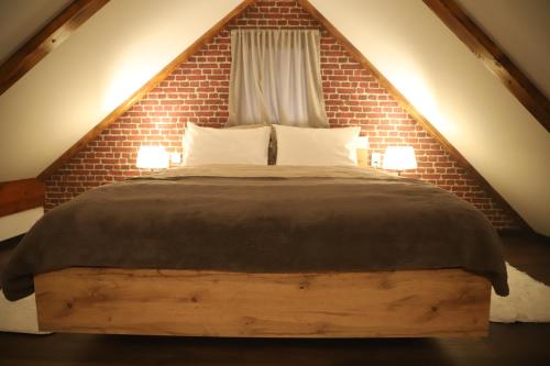 a bedroom with a large bed with a brick wall at Kuća za odmor GUSKA in Kopačevo