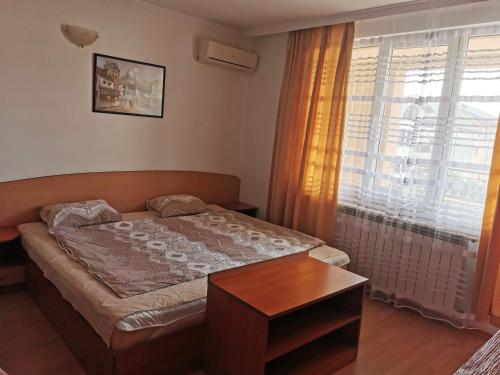 a small bedroom with a bed and a window at Къща за гости Aтанасов II in Primorsko