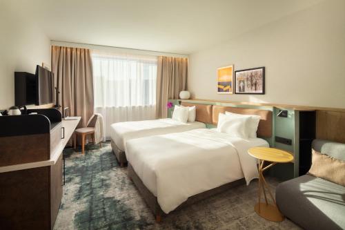 a hotel room with a bed, desk, chair, and nightstand at Crowne Plaza Budapest, an IHG Hotel in Budapest
