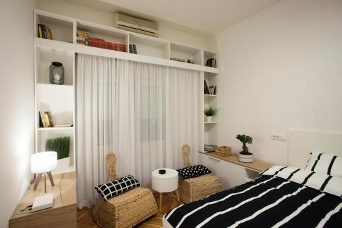 a bedroom with a bed and two chairs and a window at Studio 10 in Belgrade