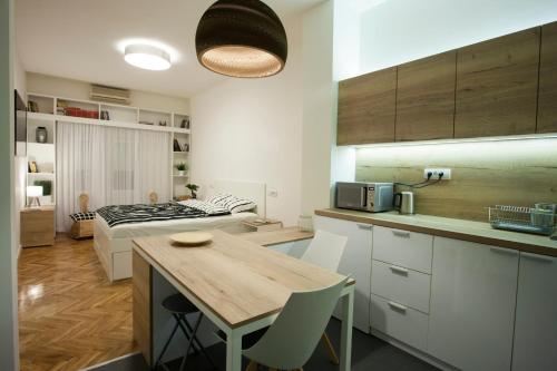 eine Küche mit einem Tisch und einem Bett in einem Zimmer in der Unterkunft Studio 10 in Belgrad