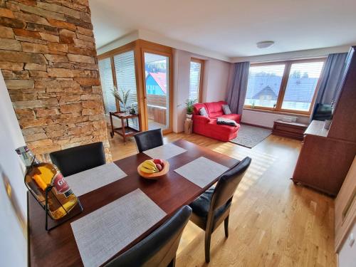 a dining room with a table and chairs and a brick wall at Horský Apartmán Klostermann in Železná Ruda