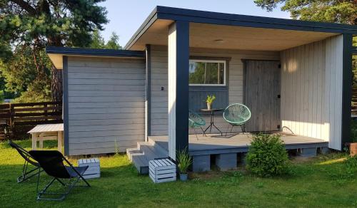 a tiny house with two chairs and a porch at Bungalow Mila Morska in Junoszyno