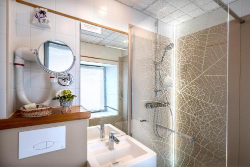 a bathroom with a shower and a sink and a mirror at Hôtel Restaurant de la Poste et La Grange Détente, espace bien-être in Châteauneuf-de-Randon