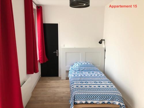 a hallway with two beds in a room with red curtains at Les appartements du quai in Dieppe