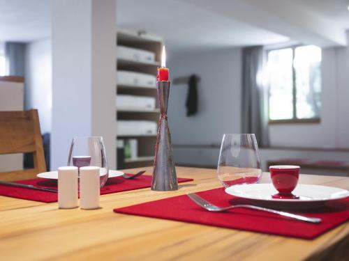 a table with a candle and red napkins and glasses at Appartement E3 in Wasserburg am Inn