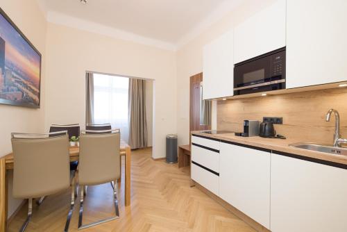 a kitchen with a table and chairs in a room at Vienna Stay Apartments Schönbrunn in Vienna