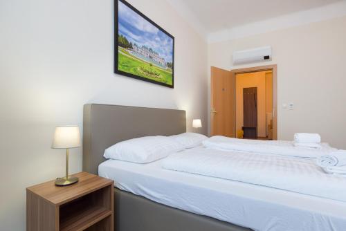 a bedroom with a bed and a tv on the wall at Vienna Stay Apartments Schönbrunn in Vienna