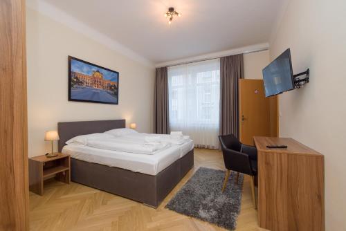a bedroom with a bed and a desk and a television at Vienna Stay Apartments Schönbrunn in Vienna
