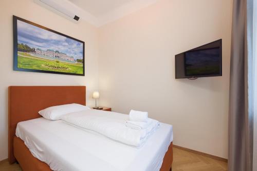a bedroom with a white bed and a flat screen tv at Vienna Stay Apartments Schönbrunn in Vienna