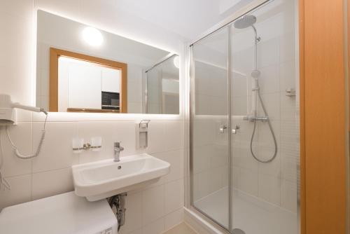 a white bathroom with a sink and a shower at Vienna Stay Apartments Schönbrunn in Vienna