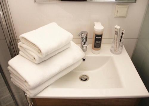 ein weißes Waschbecken mit Handtüchern darüber in der Unterkunft O&O Hotel Oberursel Zentrum in Oberursel