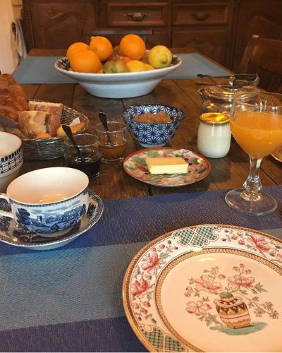 un tavolo in legno ricoperto di piatti e ciotole di cibo di les chambres de la tour a Le Bec-Hellouin