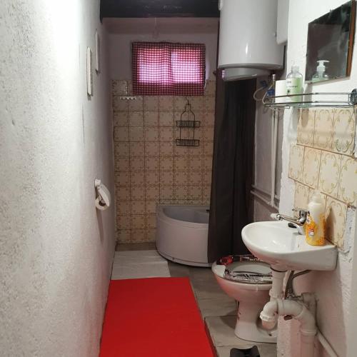 ein Badezimmer mit einem WC, einem Waschbecken und einer Badewanne in der Unterkunft Vila Brajčić in Radatovići