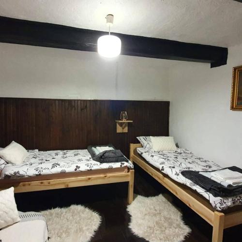 2 Einzelbetten in einem Zimmer mit einer Lampe in der Unterkunft Vila Brajčić in Radatovići