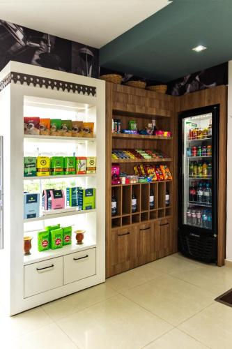a store with an open refrigerator with food inside at Sadas Hotel in São Mateus do Sul