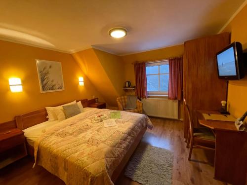 a bedroom with a bed and a desk and a television at Berghotel Drei Brüder Höhe in Marienberg
