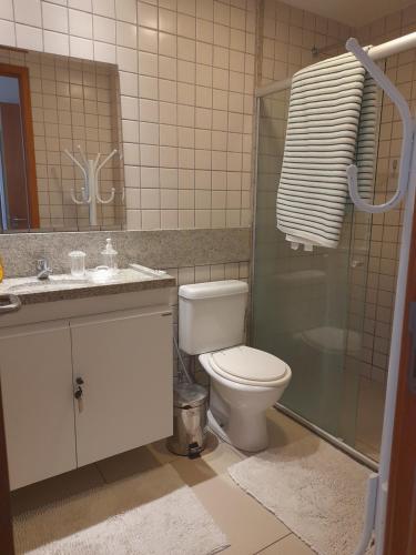 La salle de bains est pourvue de toilettes, d'un lavabo et d'une douche. dans l'établissement Aconchegante Flat em condomínio na beira mar de Muro Alto - Malawi Beach Resort, à Porto de Galinhas
