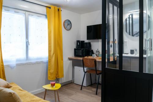 un salon avec un canapé et une table dans l'établissement Belle petite chambre privée de 9m2, avec SDC et WC, Wifi et Netflix, à Saint-Brieuc