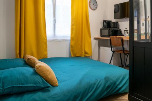 - un lit avec une couverture bleue et un rideau jaune dans l'établissement Belle petite chambre privée de 9m2, avec SDC et WC, Wifi et Netflix, à Saint-Brieuc