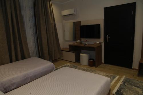 a hotel room with two beds and a television at Jewel Assiut Hotel in Asyut
