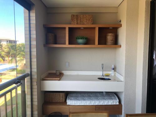 a bathroom with a sink next to a balcony at Mandara Kauai - Apartamento 3 quartos Porto das dunas in Mangabeira