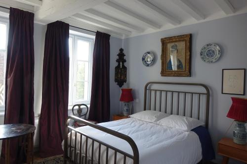 1 dormitorio con cama blanca y ventana en les chambres de la tour, en Le Bec-Hellouin