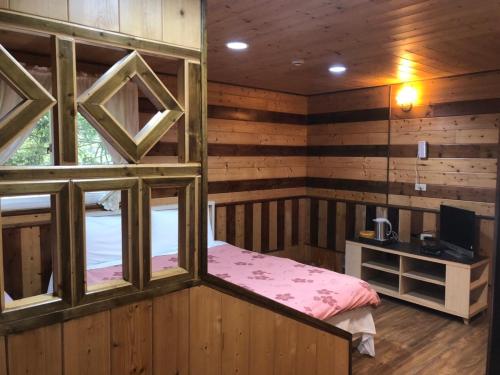 a room with a bed and a television in it at 溪景生態農莊 桃園市民宿037號 in Hualing