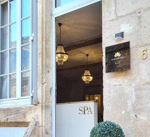 a door to a spa with chandeliers and a sign at La Dolce Vita Spa privatif in Dole