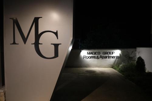 a sign for a wiegogo group roostersauts sign at night at MAGICO Rooms & Apartments in Niš