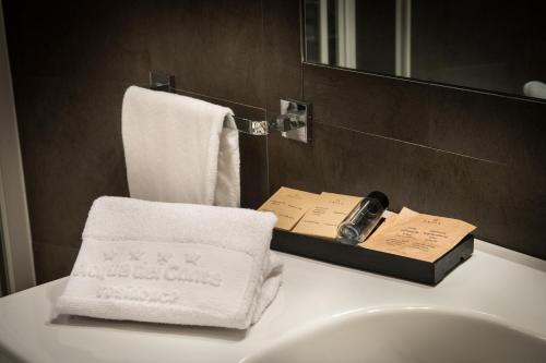ein Bad mit einem Waschbecken, Handtüchern und einem Spiegel in der Unterkunft Residence Acqua del Conte in Messina