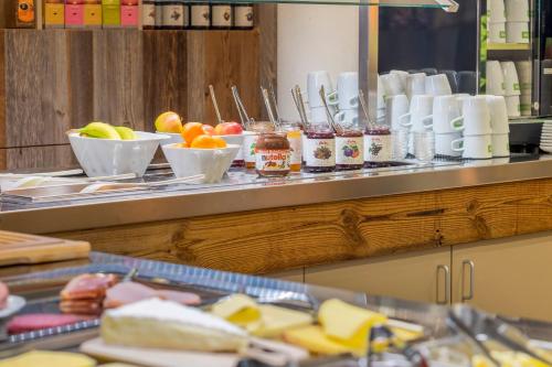 a buffet line with bowls of fruit and cheese at Explorer Hotel Montafon in Gaschurn
