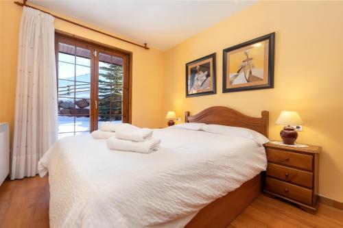 a bedroom with a large bed and a window at Pie de pistas Fontcanaleta Lamolina in La Molina