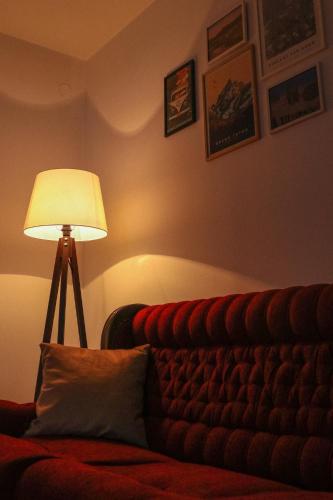 una lampada posta accanto a un divano in una stanza di Apartment '84 a Pale