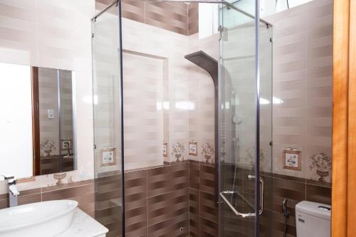 uma cabina de duche em vidro numa casa de banho com WC em Sao Mai Hotel & Apartment em Vung Tau