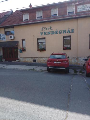肖普朗的住宿－TÖRÖK VENDÉGHÁZ，停在大楼前的红色汽车